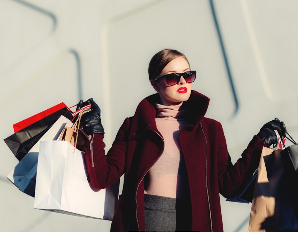 Como seu comportamento de consumo pode afetar sua qualidade de vida financeira photo of woman holding white and black paper bags