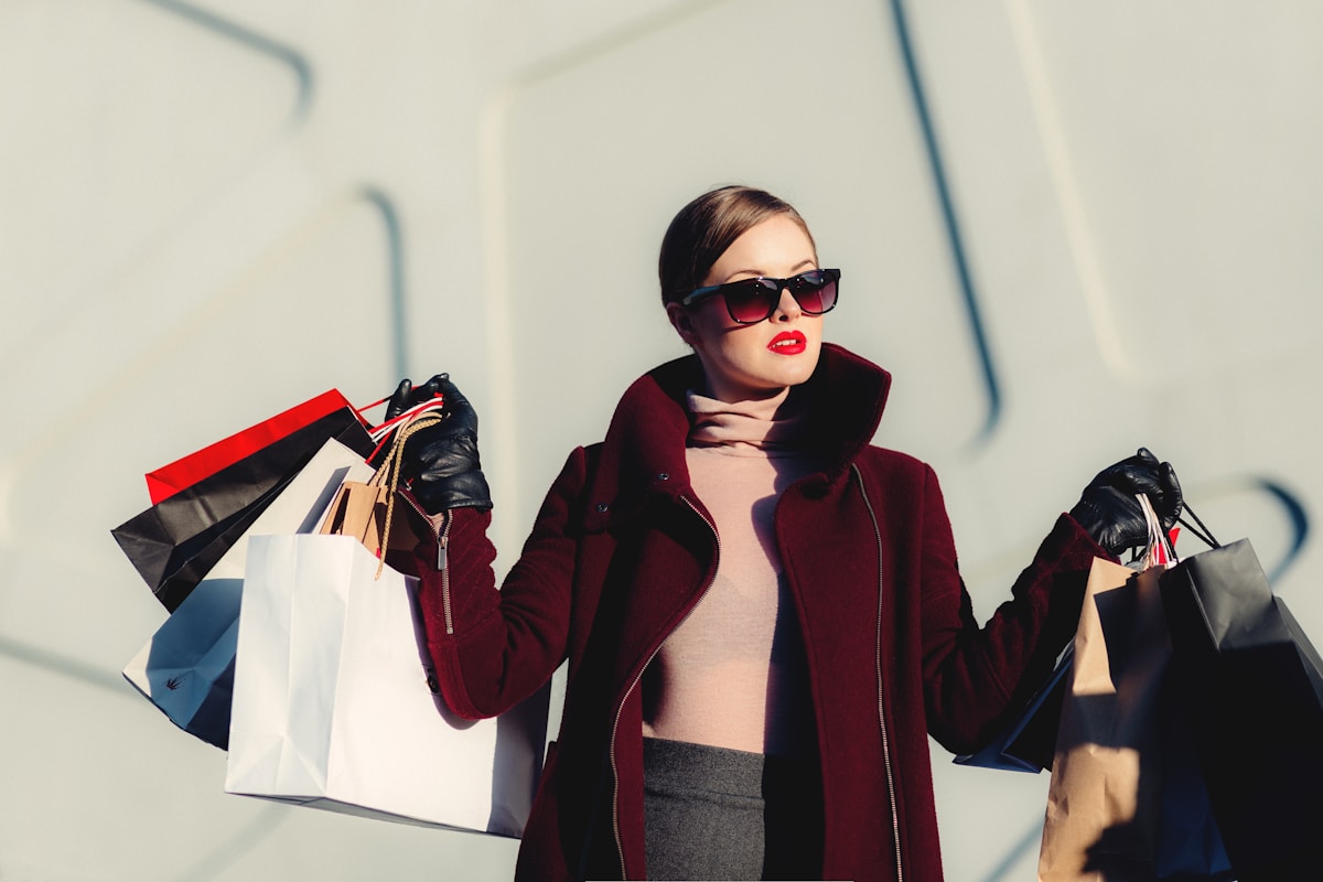 A moda premium como expressão de estilo de vida e identidade photo of woman holding white and black paper bags