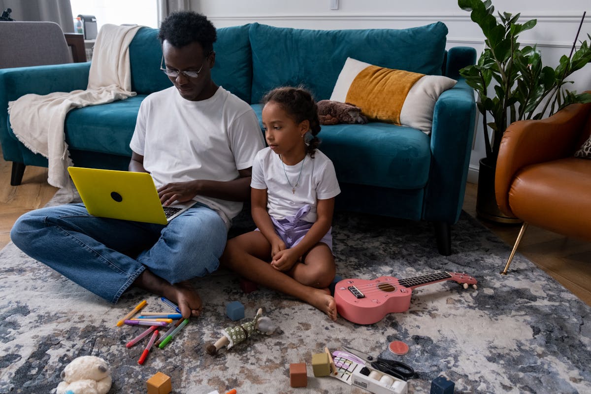 A Girl Sitting Beside a Man Using a Laptop