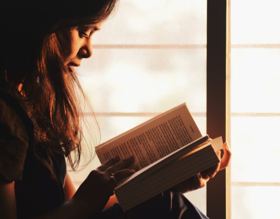 Leitura: como ela pode melhorar sua saúde mental Woman Reading a Book Beside the Window