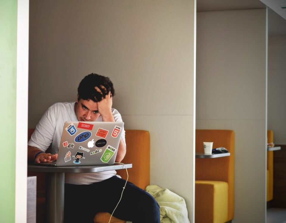 Diploma universitário e saúde mental: existe uma ligação? man wearing white top using MacBook