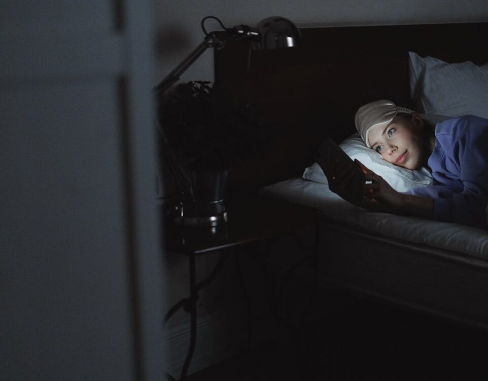 Woman Lying on Bed while Using a Cellphone