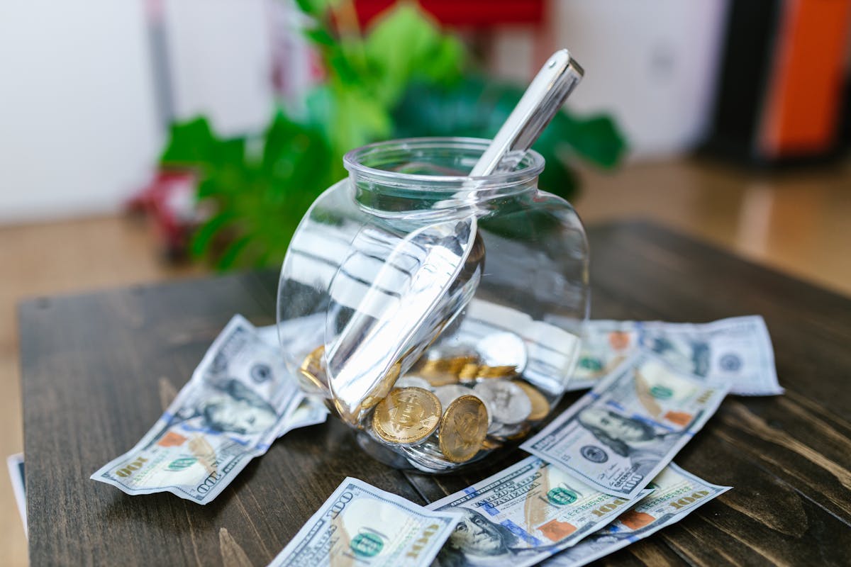 Saúde financeira: o impacto do planejamento no bem-estar Glass Container with Stainless Scooper surrounded with Paper Bills