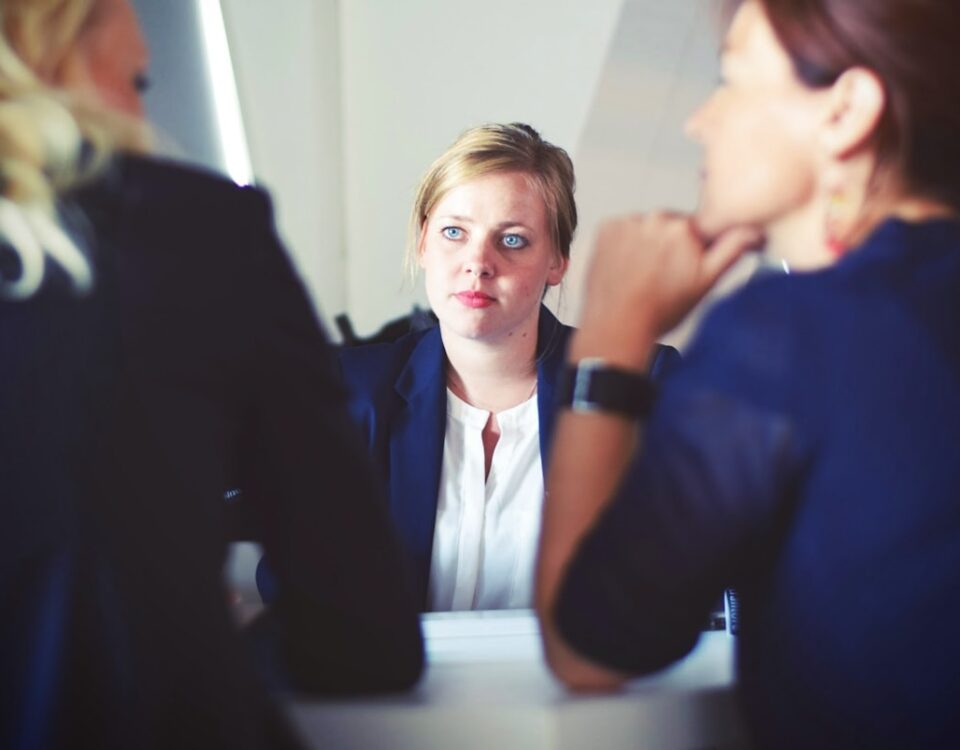three women sitting beside table