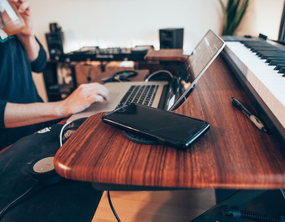 Como a internet de fibra pode melhorar sua qualidade de vida black Android smartphone beside MacBook Pro on top of brown table
