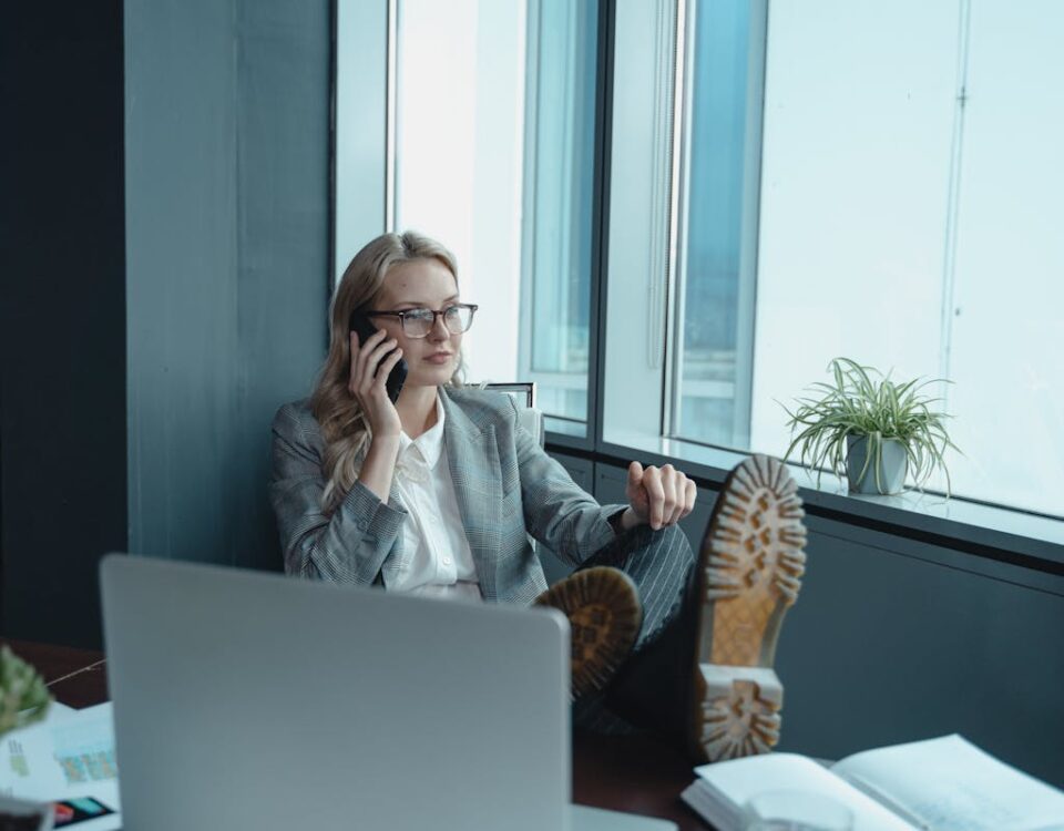 Reduzindo o estresse na gestão de vendas Professional woman in office setting, relaxed yet focused, making a call.
