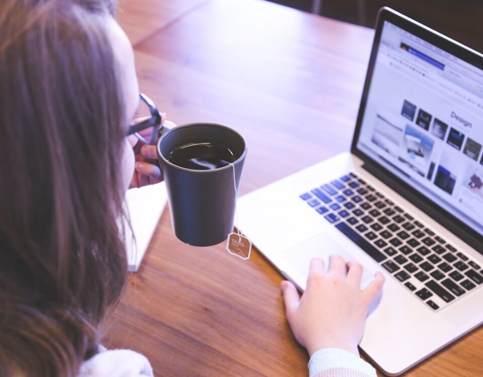 Organização de dados corporativos: o papel do backup em nuvem woman holding tea filled mug using MacBook