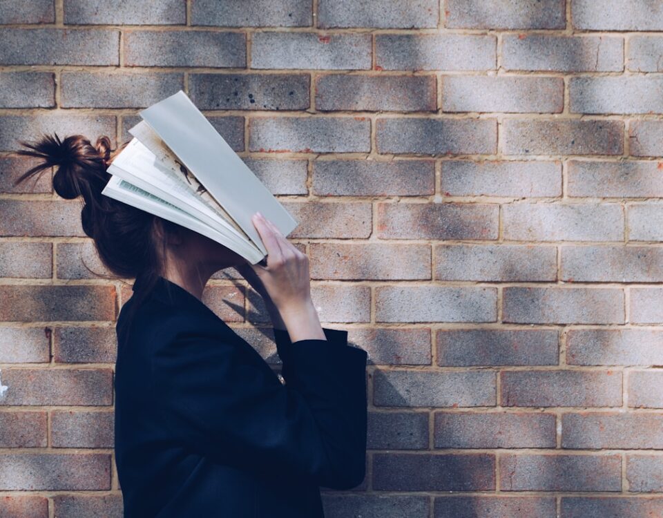 Métodos de estudo que promovem equilíbrio e bem-estar woman covering her face with white book
