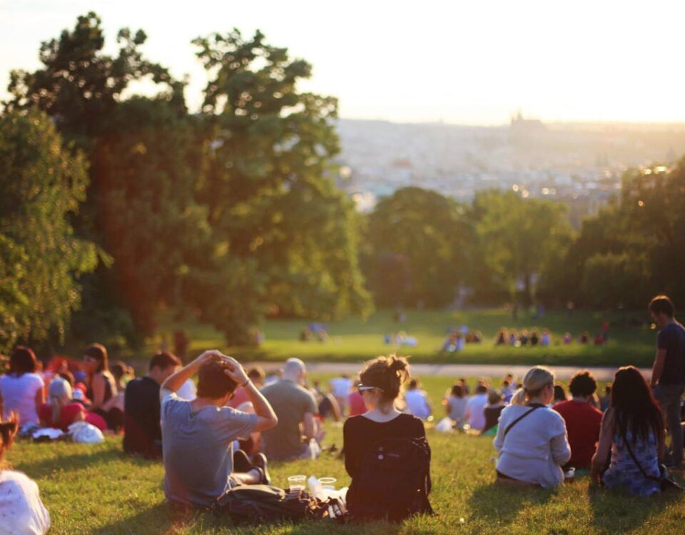 Como políticas de lazer impactam a qualidade de vida People relaxing and enjoying a sunny day in a bustling city park.