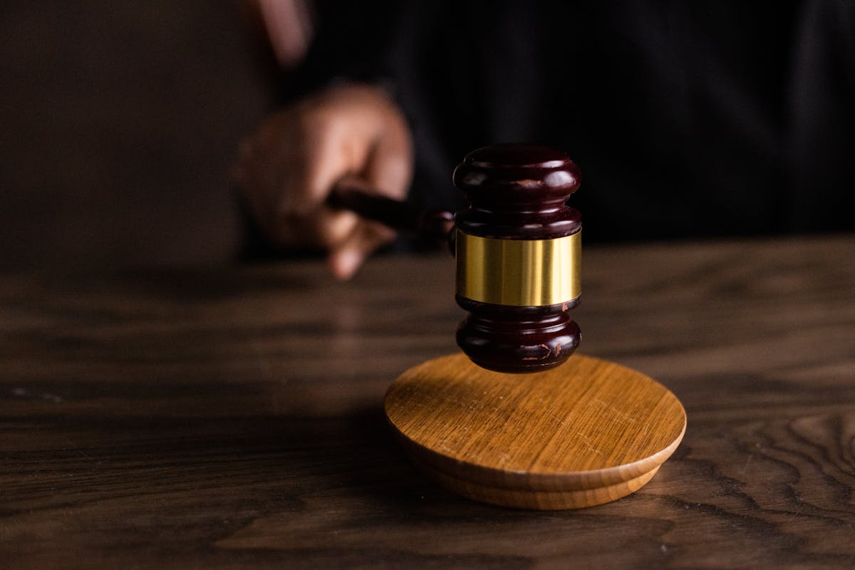 O impacto emocional de um processo criminal na vida do réu A gavel striking a sound block, symbolizing justice and legal authority in a courtroom setting.