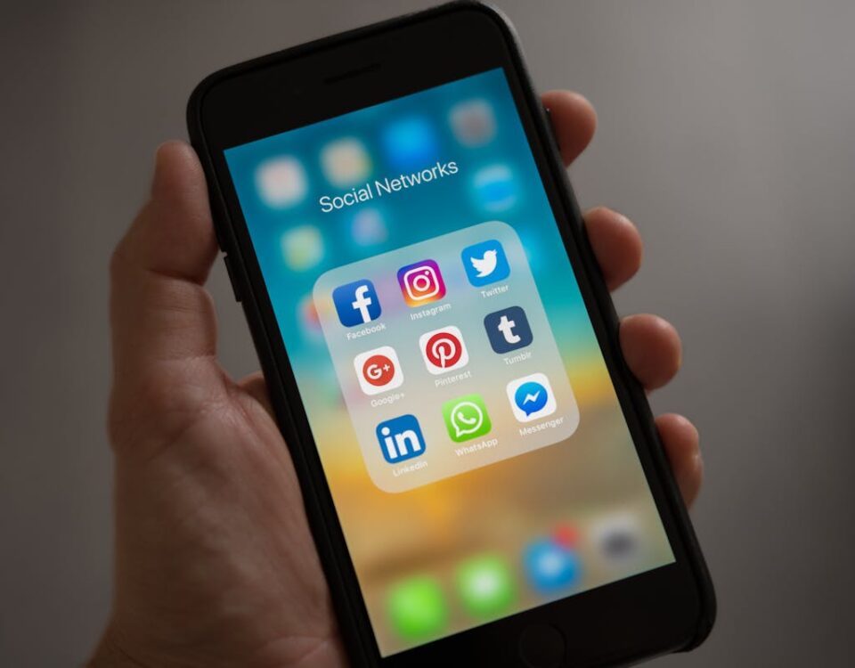 Redes sociais e saúde mental: O impacto no uso do Instagram A smartphone displaying various social media icons held in a hand, showcasing modern communication apps.
