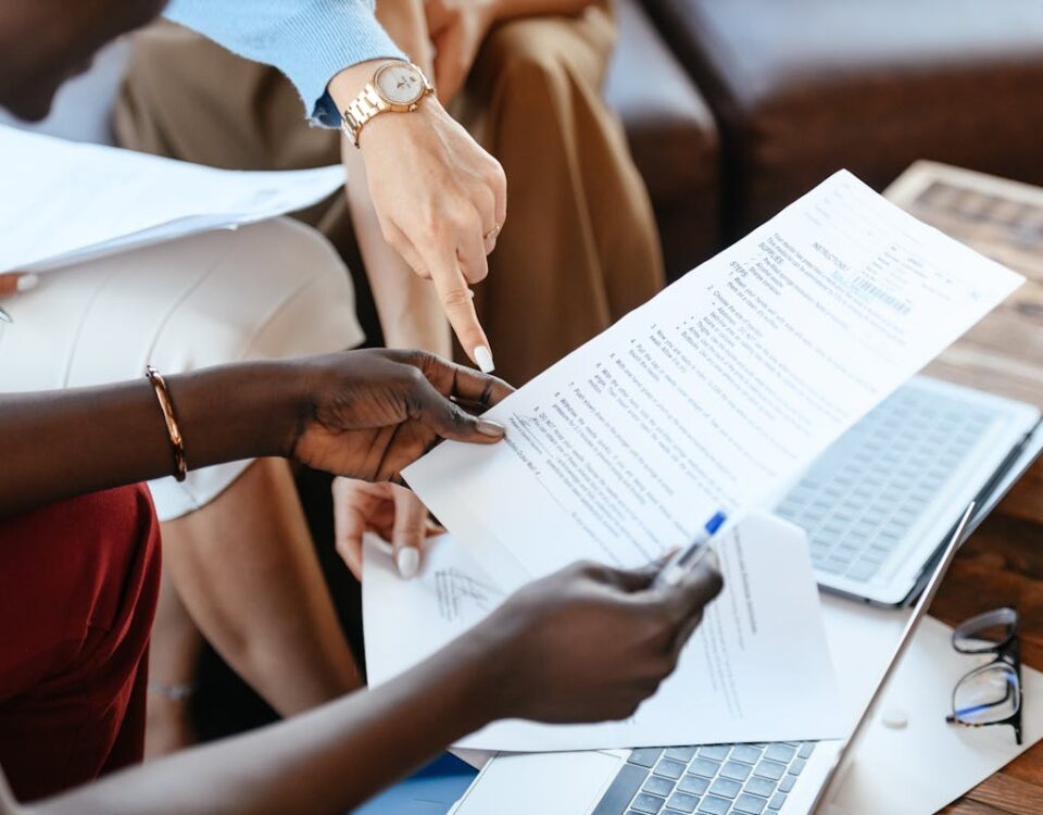 Como evitar estresse ao delegar tarefas a um despachante Group of professionals reviewing documents during an office meeting, emphasizing teamwork and strategy.