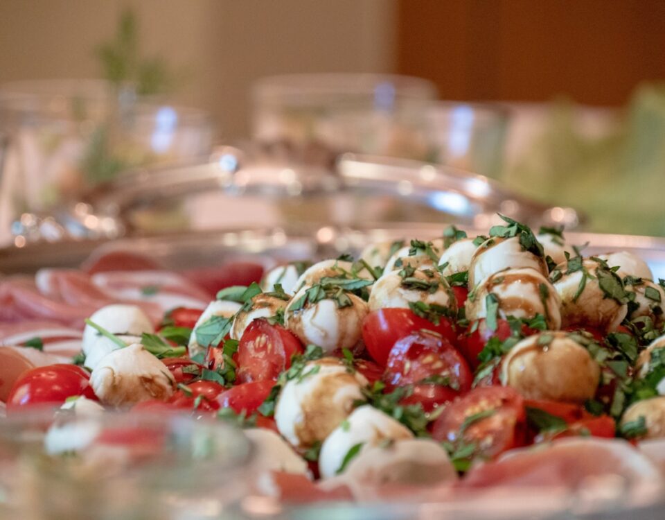 Alimentação equilibrada em eventos: É possível? a plate of food that includes tomatoes and mozzarella