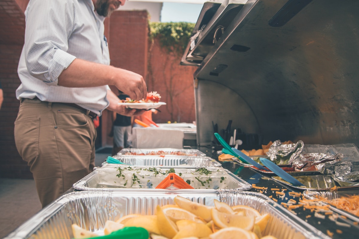 Alimentação equilibrada em eventos: É possível? man picking foods on trays