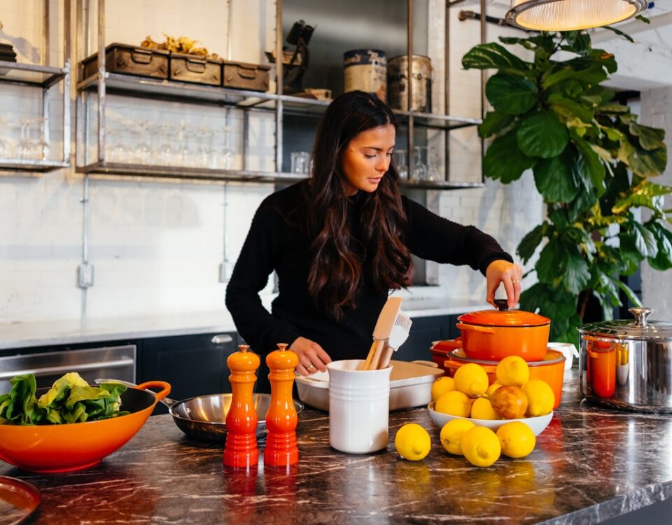Qual estilo de vida ajuda a reduzir o valor do plano de saúde? woman standing in front of fruits holding pot's lid