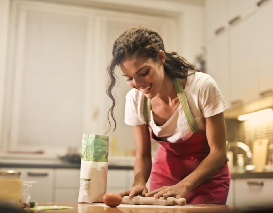 Cozinhar pode ser uma terapia? Smiling woman making dough at home, enjoying the baking process.