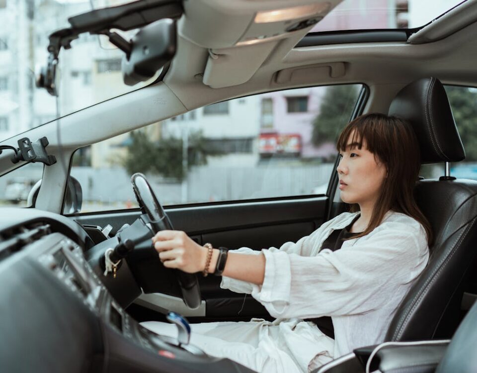 Como controlar a ansiedade antes de dirigir Confident young woman driving in the city, focused and pensive.