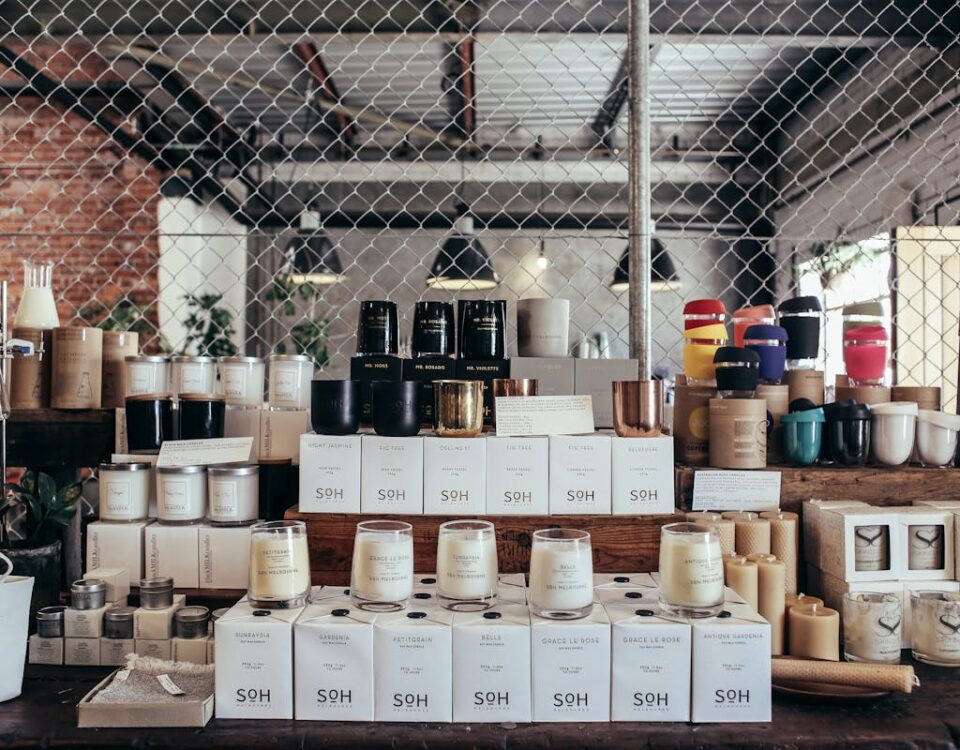 O impacto visual dos rótulos adesivos no dia a dia A curated display of handmade candles and home goods on a rustic counter, perfect for cozy interiors.
