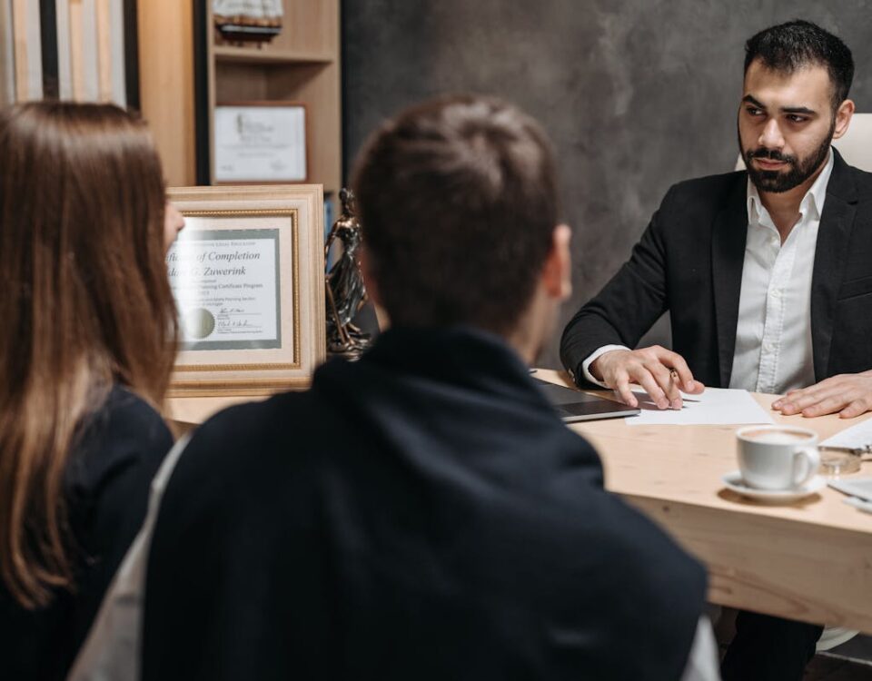 Advogados podem ajudar em reajustes abusivos de planos? A lawyer in an elegant office meeting with clients, discussing documents.