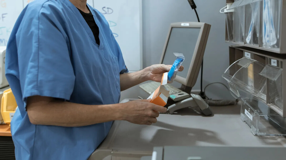Anvisa apreende lotes falsos de Dysport e Keytruda: o que fazer Profissional de saúde organizando caixas de medicamentos em prateleira