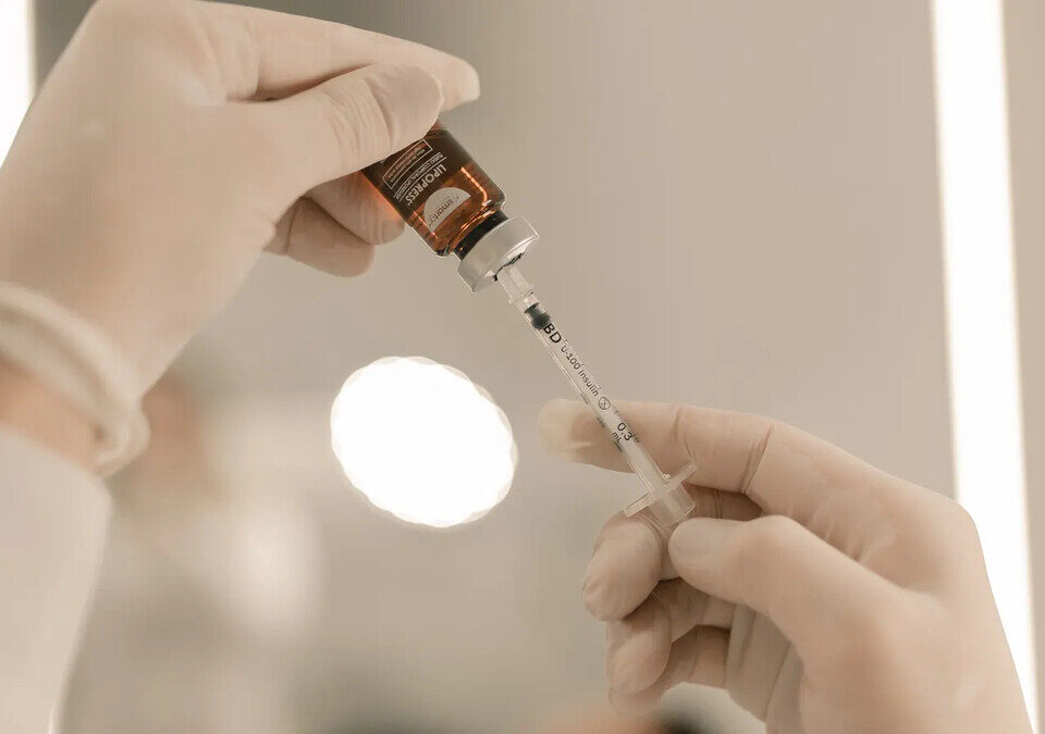 Profissional de saúde prepara medicação injetável em ambiente clínico