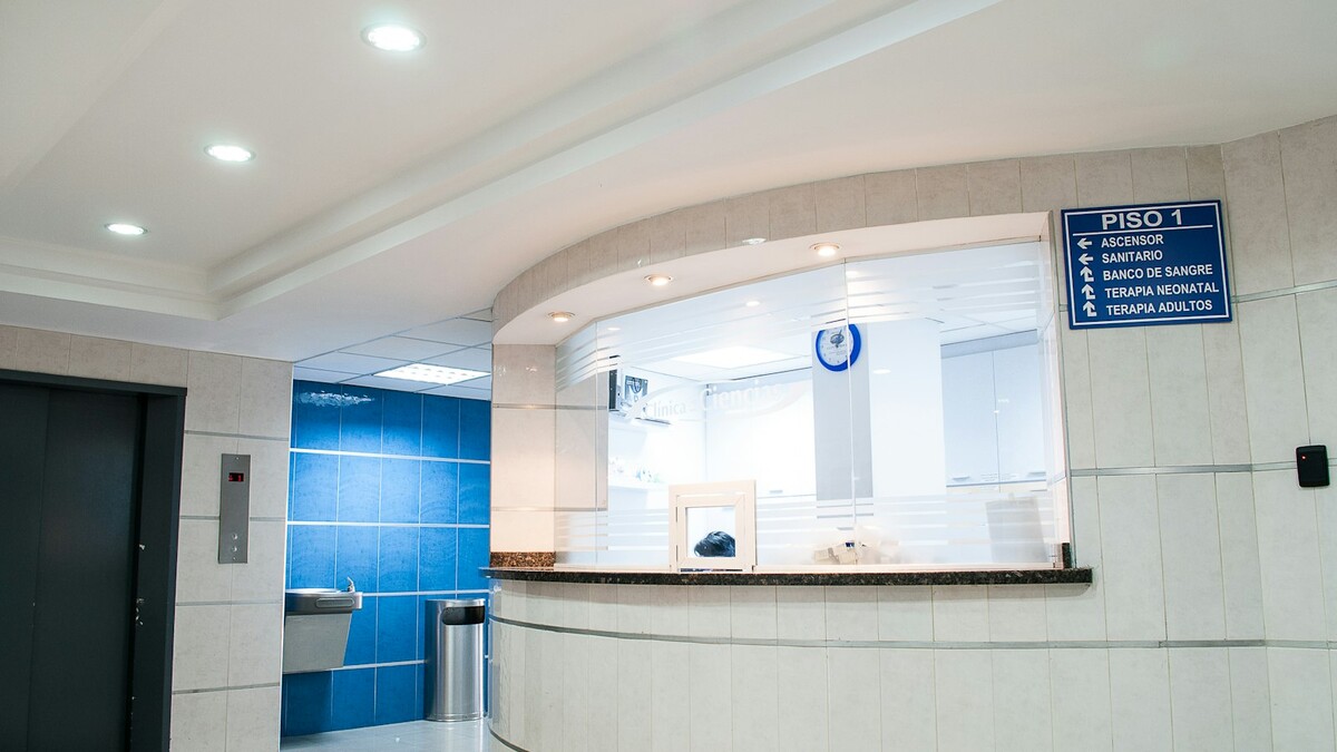 Recepção de um hospital com sinalização e balcão de atendimento