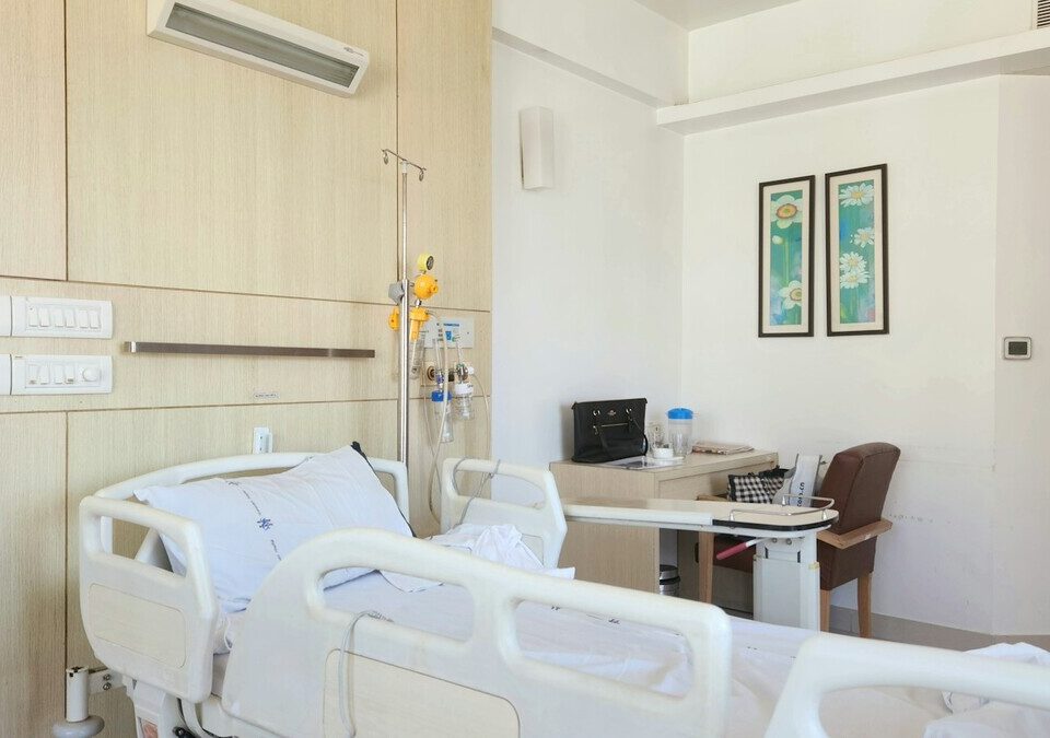 Quarto de hospital com cama e mesa de apoio