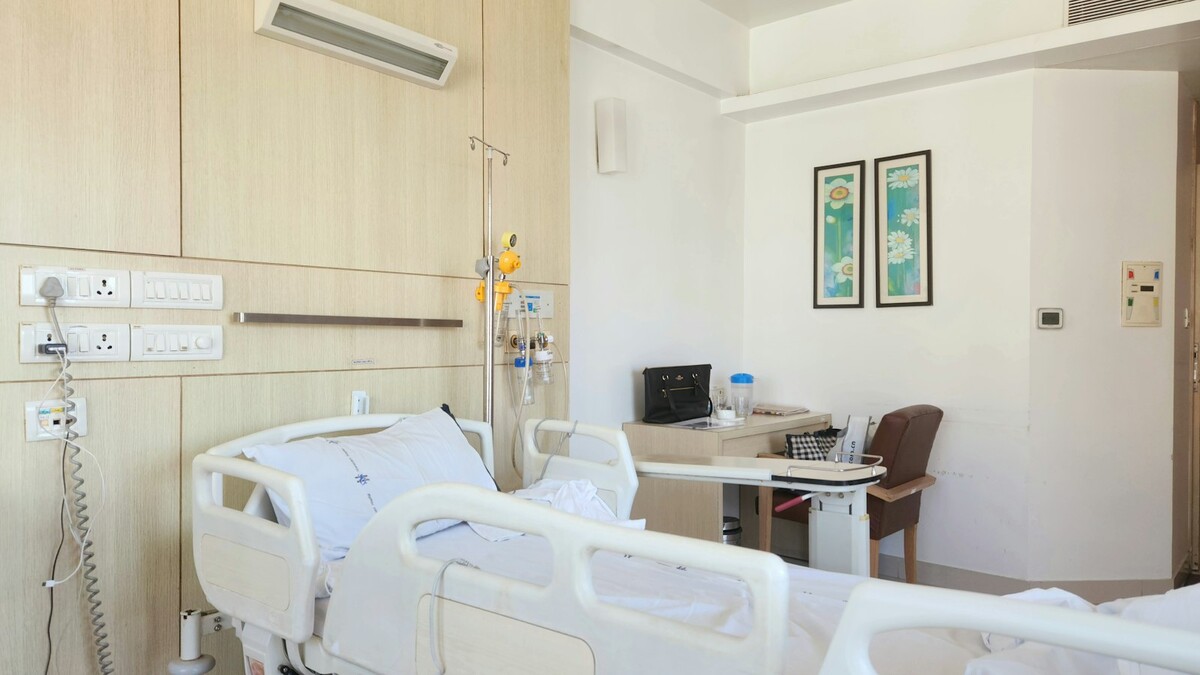 Quarto de hospital com cama e mesa de apoio