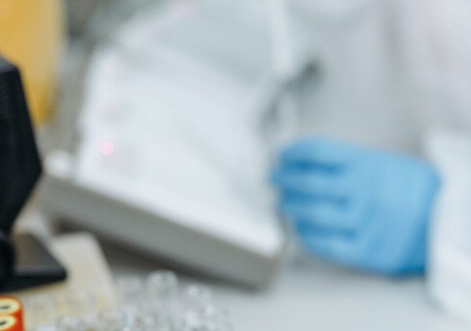 Profissional de laboratório com luvas manuseando amostras