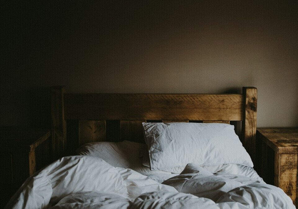 Cama desarrumada em um quarto escuro