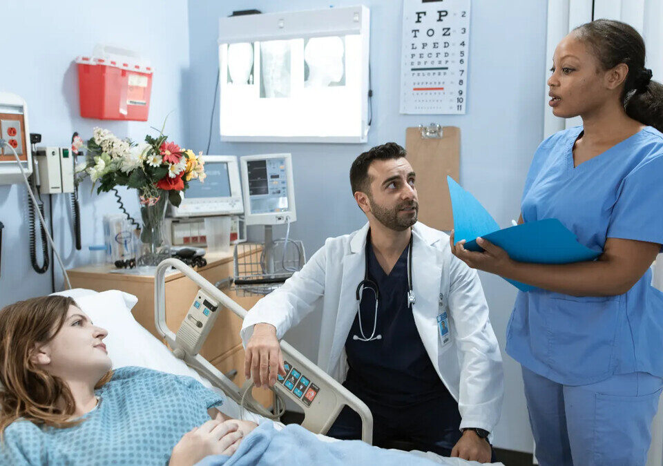 Teste FIT no SUS: quem pode fazer o rastreio do câncer de intestino Médicos conversando com paciente em quarto de hospital
